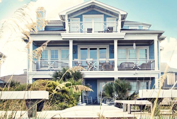 Secondary Home Insurance - Luxury Beach Front Vacation Home with Multiple Balconies and Private Dock in the Summer at Dusk